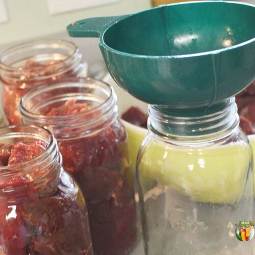 Packing quart jars with pieces of raw meat.