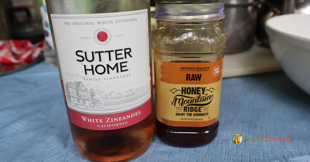 Bottle of Sutter Home white wine and Mountain Ridge raw honey.
