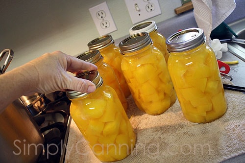 Tightening screw bands on jars of pumpkin.