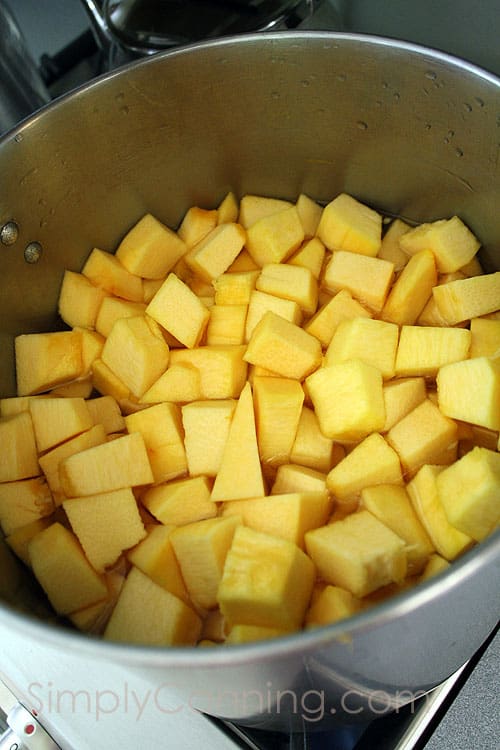 Pot filled with cubes of raw pumpkin.
