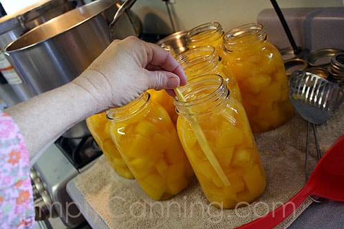 Removing bubbles from jars filled with cubed pumpkin.