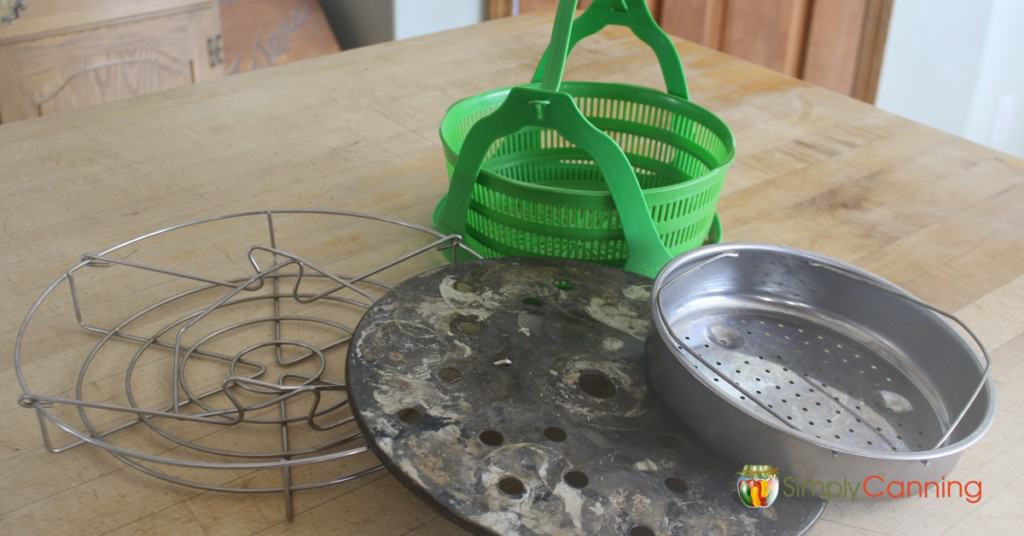 Various styles of metal and silicone canning racks spread over the countertop.