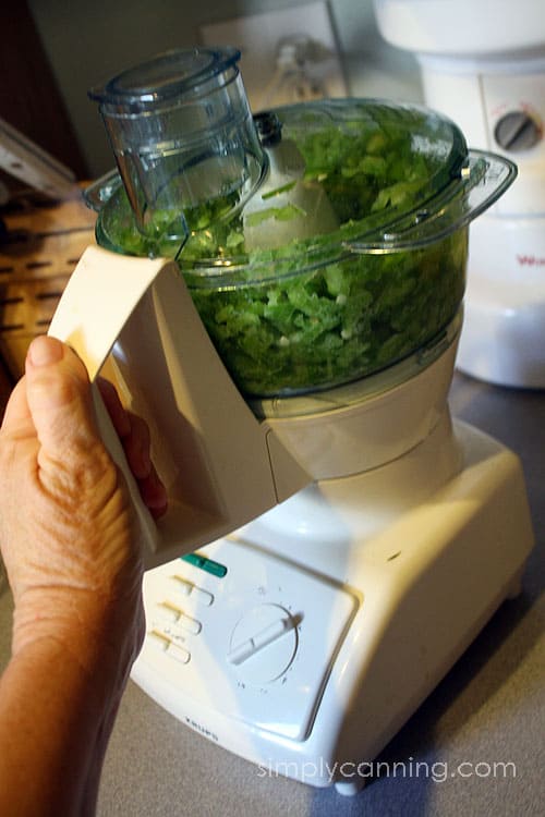 Chopping green bell peppers in a small food processor.
