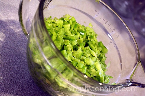 A large glass measuring bowl filled with chopped vegetables.