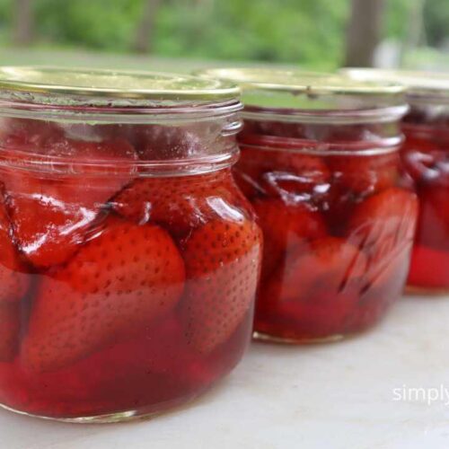 Finished jars of strawberries showing a small amount of floating. 