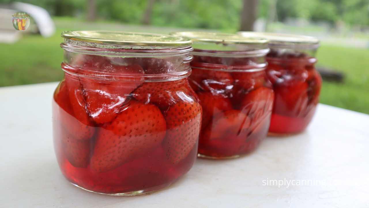 Finished jars of strawberries showing a small amount of floating. 