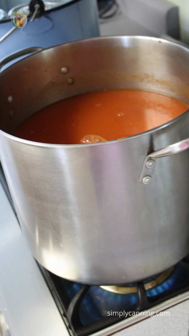 Stock pot of tomato juice simmering on the stove.