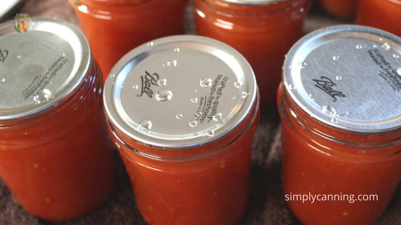 Close up of 5 jars of tomato juice. 
