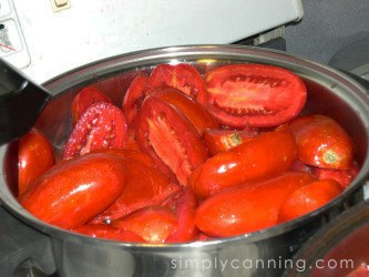 Raw halved tomatoes in a stockpot.