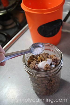 Measuring salt into a jar of ground meat.