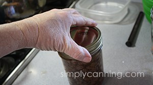 Screwing a ring on the jar of ground venison.