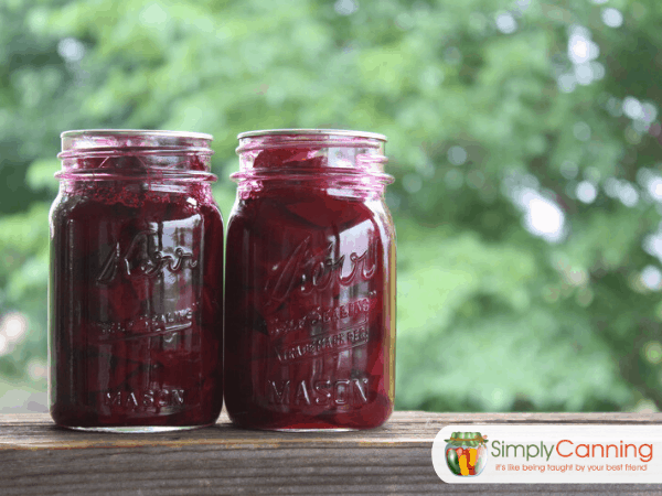 Jars filled with bright red pickled beets.