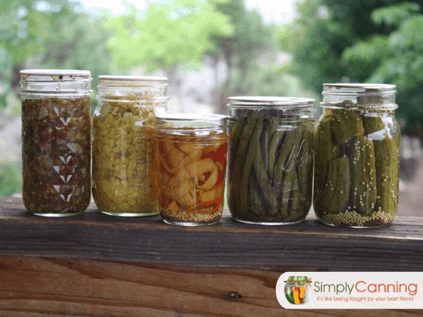 Canning jars of various sizes and shapes filled with different types of food.