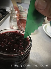 Measuring headspace on a jar of cherry jam.