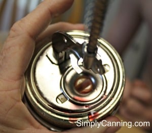 Looking down at the lid where you place the cherry in the indentation and push the spring down into the fruit to remove the pit.