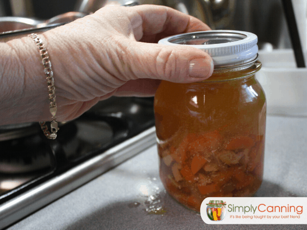 Tightening a ring on a jar of chicken soup.