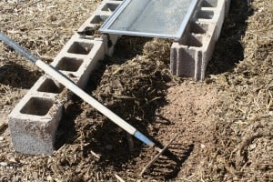 Raking up a layer of straw during the cold frame construction.