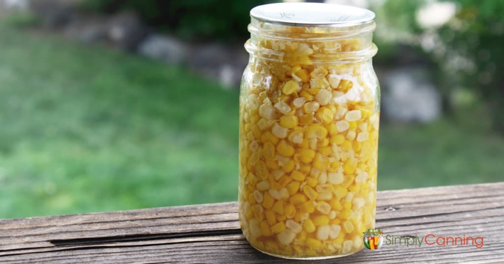 A pint jar of golden sweet corn kernels.