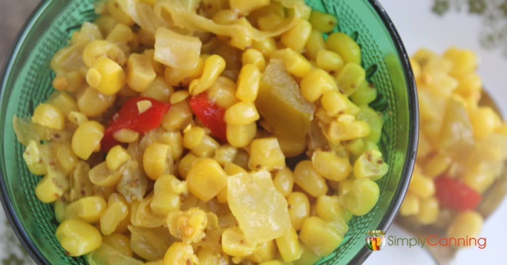 Colorful mixture of corn relish in a deep green dish.