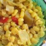 Colorful mixture of corn relish in a deep green dish.