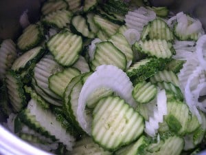 A mixture of crinkle cut onion and cucumber slices.
