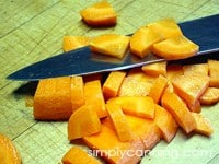 Slicing carrots into pieces using a chef's knife.