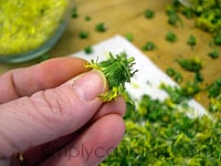 Pinching off the green parts from the flower heads. 