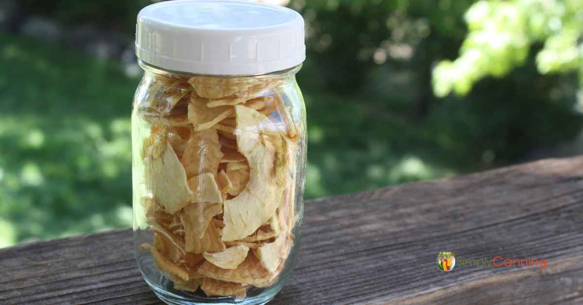 A glass jar filled with dried apple slices.