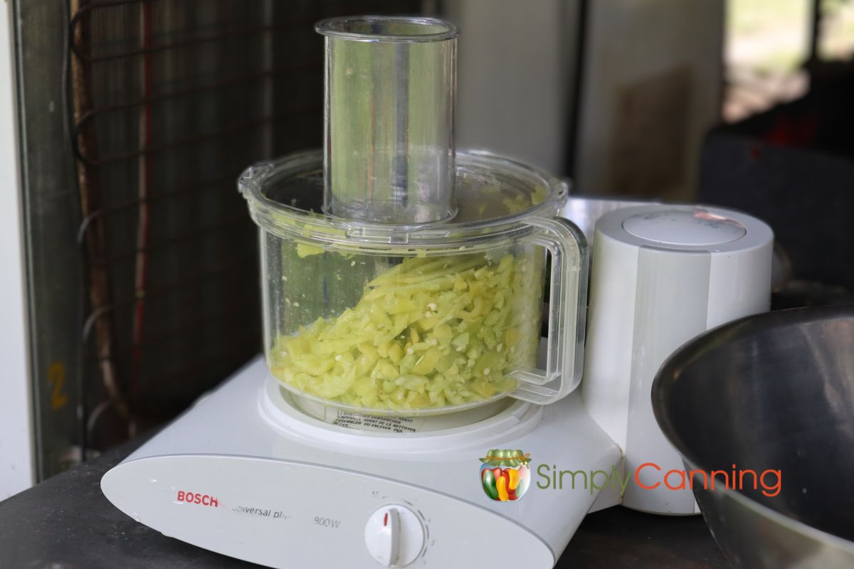 Light green banana peppers chopped in a food processing bowl.