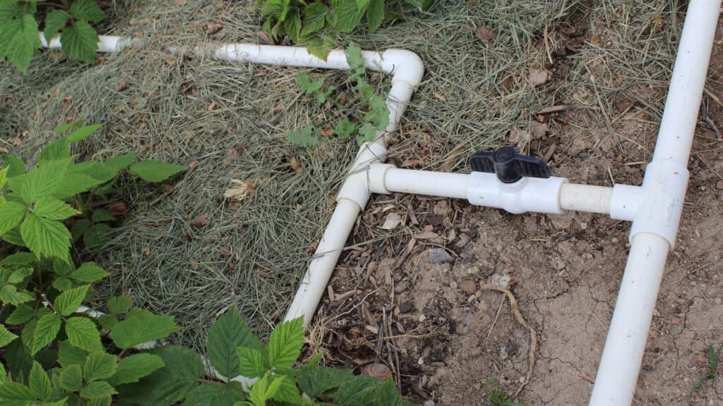 PVC pipe laid out over the ground in the garden.