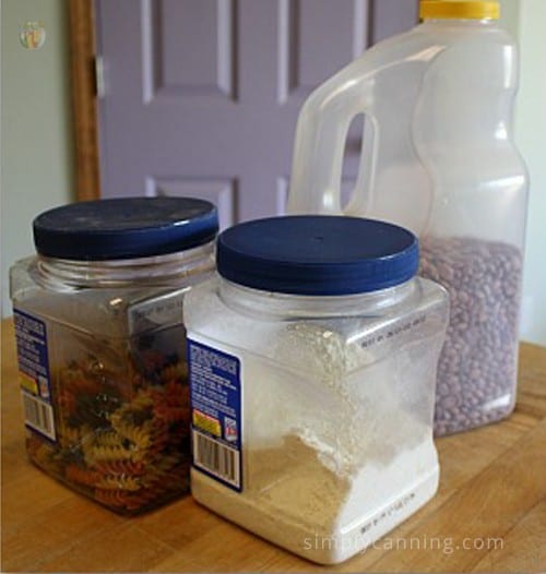 Various plastic containers filled with dry goods like pasta and beans.