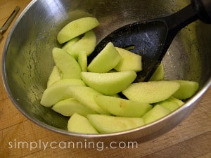 Stirring to coat freshly sliced apples with sugar.