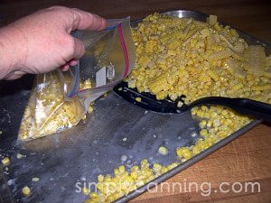 Filling freezer bags with corn kernels.