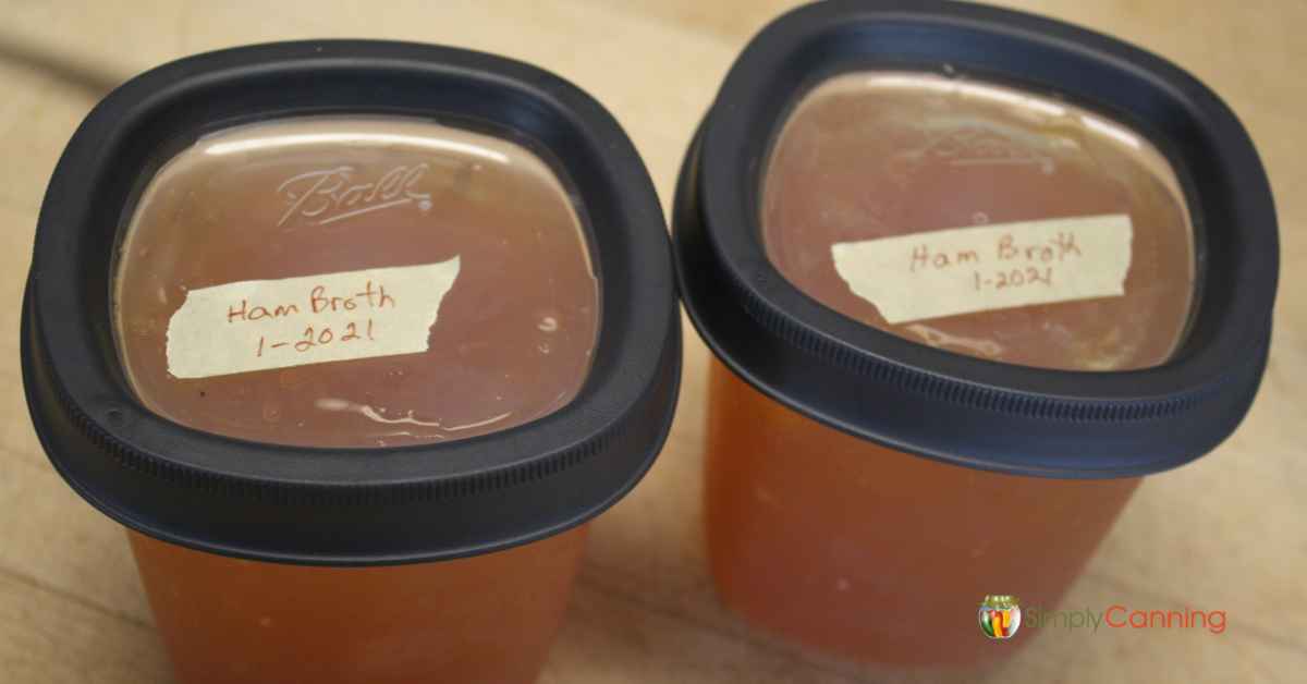 Freezer jars filled with ham broth and labeled with the date.