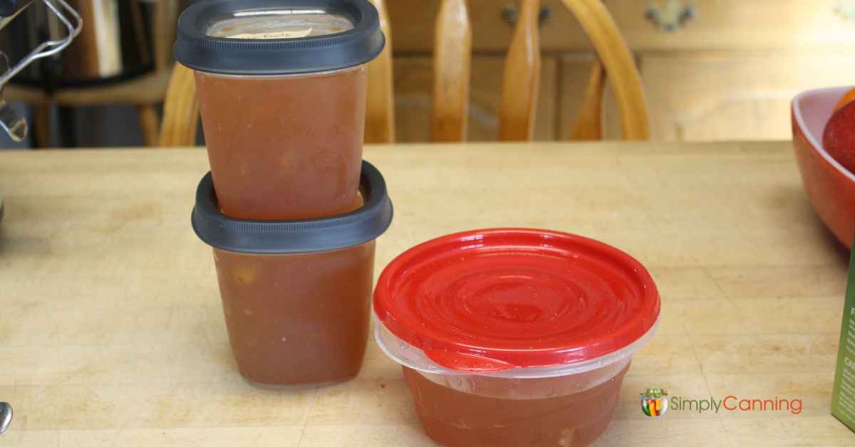 Freezer containers of ham broth sitting on the countertop in the kitchen.