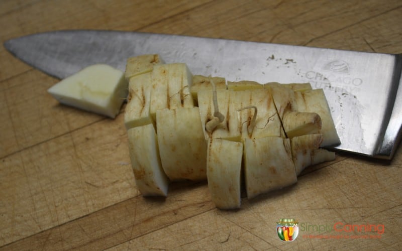Chopping parsnips into smaller chunks.