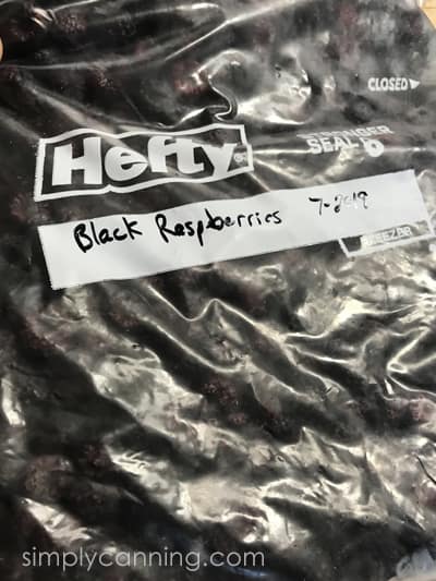 A labeled freezer bag filled with black raspberries.