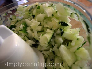 Dark green zucchini being chopped in a food processor.