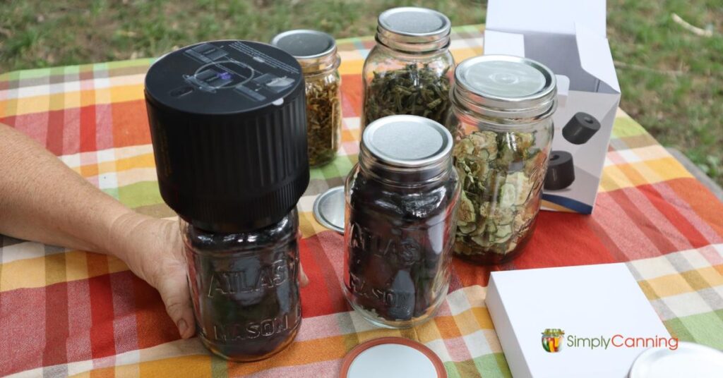 Glass Jar with Vacuum Sealer, various jars of dehydrated foods ready to be sealed.