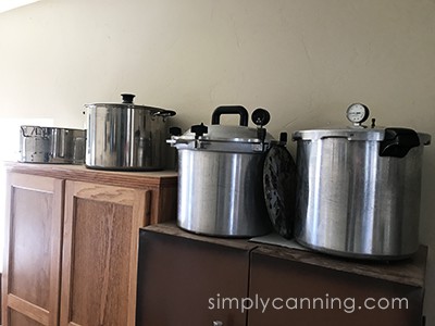 Pressure canners and other large pots sitting on top of both cabinets.