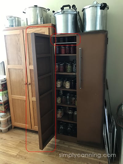 Metal storage cabinet filled with lots of home canned food.