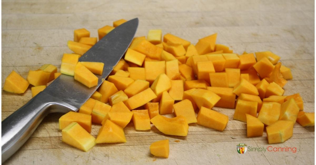 Knife and peeled and chopped butternut squash.