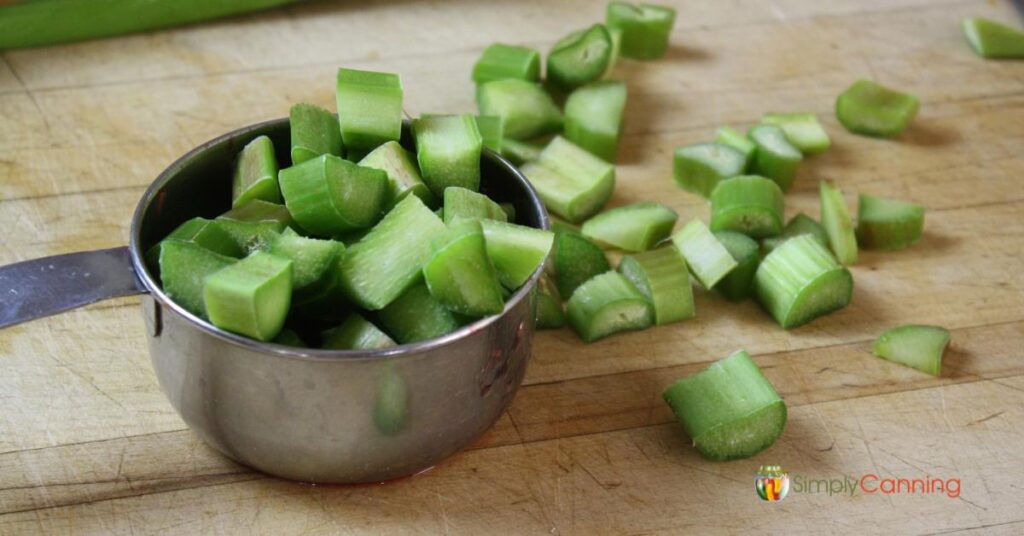 Chopped rhubarb in a 1 cup measuring cup.