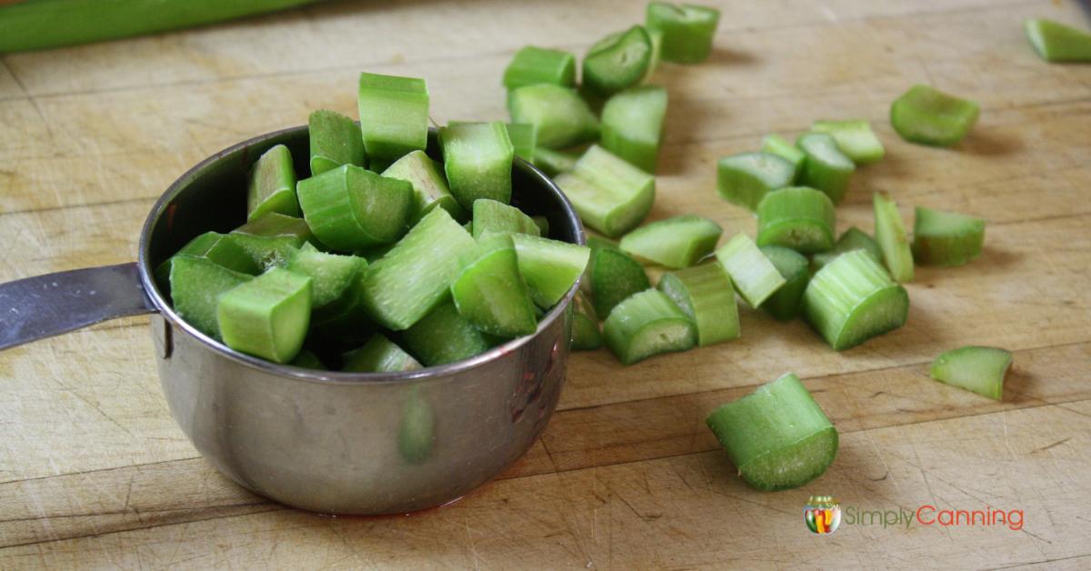Chopped rhubarb in a 1 cup measuring cup.
