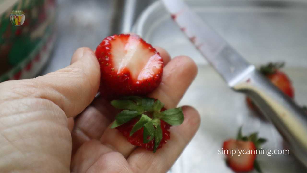 Strawberry with the top green stem removed by a knife. 