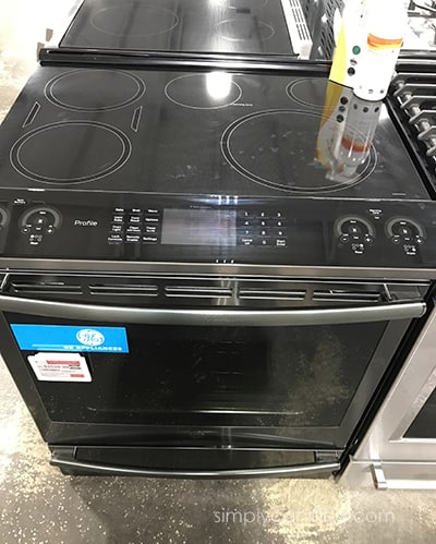Black colored induction stove top with oven underneath it.