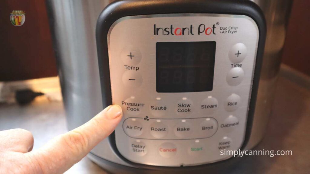 Close up of the Instant Pot control panel with my finger pointing at the Pressure Cook option.  