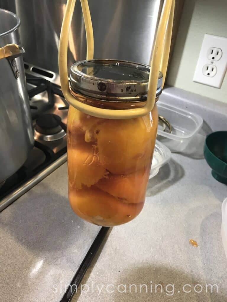 lifting jar of peaches