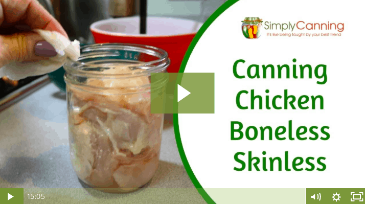 Wiping the rim of a jar packed with raw chicken pieces, links to member lesson on canning boneless chicken.