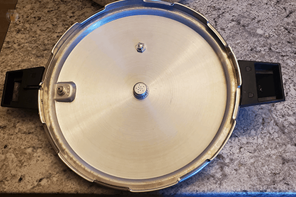 The inside of the Mirro pressure canner lid with the seal and inside mechanics clearly visible.